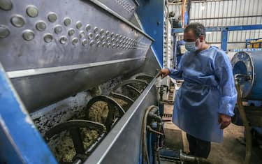A worker watches as olives are crushed inside a machine at an olive oil factory in Khan Yunis, in the southern Gaza Strip on October 4, 2020. (Photo by SAID KHATIB / AFP) (Photo by SAID KHATIB/AFP via Getty Images)