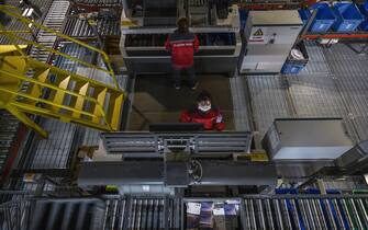 BEIJING, CHINA - NOVEMBER 11: Workers from Chinese e-commerce giant JD.com work on an automated sorting machine at the company's main logistics hub during an organized tour for Singles Day on November 11, 2020 in Beijing, China. The online shopping blitz, known as Singles Day or Double 11, is the world's largest retail event and comes as Chinese consumers are emerging from the COVID-19 pandemic. The revival of consumer consumption is expected to boost China's economy, which is already showing signs of post-pandemic recovery and providing a bright spot for global brands and retailers. Singles Day sales for China's biggest e-commerce giants like JD.com are on pace to break previous records, pulling in $56 billion U.S. in the first 30 minutes, when combined with three days of pre-event sales. (Photo by Kevin Frayer/Getty Images)