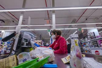 A cashier wearing a face masks processes a customer's payment at a supermarket on March 26, 2020 in the Portuense district of Rome during the country's lockdown following the COVID-19 new coronavirus pandemic. (Photo by ANDREAS SOLARO / AFP) (Photo by ANDREAS SOLARO/AFP via Getty Images)