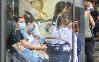 SYDNEY, AUSTRALIA - DECEMBER 21: People are seen at a bus stop in Bondi Junction on December 21, 2020 in Sydney, Australia. Sydney's northern beaches is on lockdown, as a cluster of Covid-19 cases continues to grow causing other Australian states and territories to impose restrictions on travel ahead of the Christmas holidays. As the list of venues impacted across Sydney increases, people are encouraged to get tested and isolate. (Photo by Jenny Evans/Getty Images)
