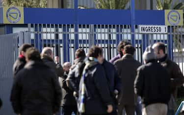 Fiat workers stand outside Termini Imerese factory, on the Italian island of Sicily, on Feruary 3, 2010 during a four-hour strike called over the "irreversible" decision to shut down the factory. Fiat announced on Feburary 2 that it would halt production at all Italian plants for two weeks from February 22 because of a fall-off in orders. AFP PHOTO / Marcello PATERNOSTRO . (Photo credit should read MARCELLO PATERNOSTRO/AFP via Getty Images)