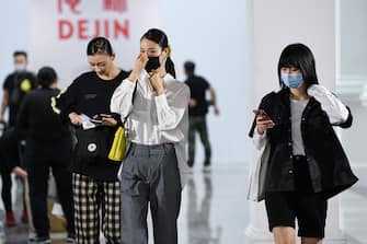 BEIJING, CHINA - MAY 03: The crew wear face masks as a preventive measure against the COVID-19 coronavirus as they left after  DEJIN collection show by Chinese designer Zhou Li during the China Fashion Week 2020/2021 A/W Collection on May 3, 2020 in Beijing, China. Affected by the COVID-19 virus, China Fashion Week is showing for the first time without an audience.  on May 03, 2020 in Beijing, China. (Photo by Yanshan Zhang/Getty Images)