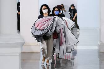 BEIJING, CHINA - MAY 03: The crew wear face masks as a preventive measure against the COVID-19 coronavirus as they leave following the DEJIN collection show by Chinese designer Zhou Li during the China Fashion Week 2020/2021 A/W Collection on May 3, 2020 in Beijing, China. Affected by the COVID-19 virus, China Fashion Week is showing for the first time without an audience. on May 03, 2020 in Beijing, China. (Photo by Yanshan Zhang/Getty Images)