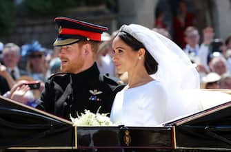 WINDSOR, ENGLAND - MAY 19:  Prince Harry, Duke of Sussex and Meghan, Duchess of Sussex leave Windsor Castle in the Ascot Landau carriage during a procession after getting married at St Georges Chapel on May 19, 2018 in Windsor, England. Prince Henry Charles Albert David of Wales marries Ms. Meghan Markle in a service at St George's Chapel inside the grounds of Windsor Castle. Among the guests were 2200 members of the public, the royal family and Ms. Markle's Mother Doria Ragland.  (Photo by Gareth Fuller - Pool/Getty Images)