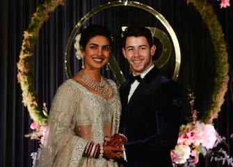 Indian Bollywood actress Priyanka Chopra (L) and US musician Nick Jonas, who were recently married, pose for a photograph during a reception in New Delhi on December 4, 2018. - Bollywood actress Priyanka Chopra and American singer Nick Jonas hosted an extravagant concert on December 2 for their star-studded wedding guests as the couple tied the knot at a lavish Indian palace. (Photo by SAJJAD HUSSAIN / AFP)        (Photo credit should read SAJJAD HUSSAIN/AFP via Getty Images)