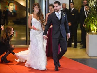 TOPSHOT - Argentine football star Lionel Messi and bride Antonella Roccuzzo pose for photographers just after their wedding at the City Centre Complex in Rosario, Santa Fe province, Argentina on June 30, 2017.
Footballers and celebrities including pop singer Shakira gathered Friday for the "wedding of the century" in Lionel Messi's Argentine hometown as the Barcelona superstar prepared to marry his childhood sweetheart Antonella Roccuzzo. / AFP PHOTO / EITAN ABRAMOVICH        (Photo credit should read EITAN ABRAMOVICH/AFP via Getty Images)