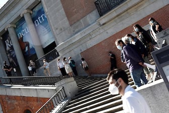 Gente in mascherina in fila davanti al museo del Prado di Madrid