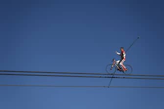 Swiss acrobat Freddy Nock poses balancing on a bicycle on the carrying cable of a cable car during the "Glacier 3000" Air show, an event marking the reopening of the Alpine facilities on June 23, 2020 above Les Diablerets following the lockdown due to the COVID-19 outbreak, caused by the novel coronavirus. (Photo by Fabrice COFFRINI / AFP) (Photo by FABRICE COFFRINI/AFP via Getty Images)