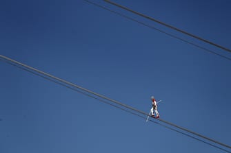 Swiss acrobat Freddy Nock balances blindfolded on the carrying cable of a cable car during the "Glacier 3000" Air show, an event marking the reopening of the Alpine facilities on June 23, 2020 above Les Diablerets following the lockdown due to the COVID-19 outbreak, caused by the novel coronavirus. (Photo by Fabrice COFFRINI / AFP) (Photo by FABRICE COFFRINI/AFP via Getty Images)
