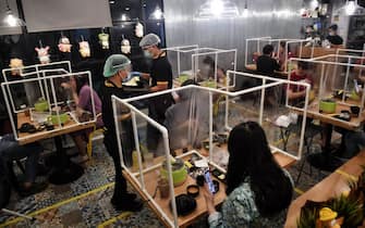 TOPSHOT - People eat in between plastic partitions, set up in an effort to contain any spread of the COVID-19 coronavirus, at the Penguin Eat Shabu hotpot restaurant in Bangkok on May 5, 2020. (Photo by Lillian SUWANRUMPHA / AFP) (Photo by LILLIAN SUWANRUMPHA/AFP via Getty Images)