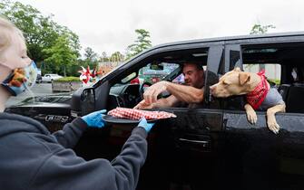 VANCOUVER, BRITISH COLUMBIA - JULY 01: Attendees pick up food following an indoor "reverse" parade for Canada Day at PNE on July 01, 2020 in Vancouver, British Columbia.The Canada Day parade was organized as a socially distanced event to allow spectators to remain in cars while driving by as entertainers perform.  (Photo by Andrew Chin/Getty Images)