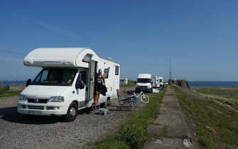 1251698511 REDCAR, UNITED KINGDOM - JUNE 24: Camper vans park up at South Gare near Redcar as people enjoy the hot weather on June 24, 2020 in Redcar, United Kingdom. A summer heatwave is expected across the country this week with weather warnings issued in some places for thunderstorms. (Photo by Ian Forsyth/Getty Images)