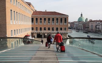VENICE, ITALY - MARCH 9: Tourists are seen with their luggage as they cross the Calatrava bridge towards the railway station as they try to leave a completely empty city on March 9, 2020 in Venice, Italy. Prime Minister Giuseppe Conte announced a "national emergency" due to the coronavirus outbreak and imposed quarantines on the Lombardy and Veneto regions, which contain roughly a quarter of the country's population. Italy has the highest number of cases and fatalities in Europe. 
The movements in and out are allowed only for work reasons, health reasons proven by a medical certificate.The justifications for the movements needs to be certified with a self-declaration by filling in forms provided by the police forces in charge of the checks.
(Photo by Marco Di Lauro/Getty Images)