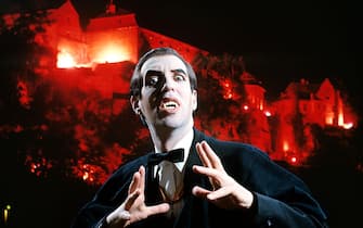 MAN IN VAMPIRE MAKEUP AND COSTUME GESTURING MENACINGLY CASTLE BACKGROUND LOOKING AT CAMERA  (Photo by H. Armstrong Roberts/ClassicStock/Getty Images)