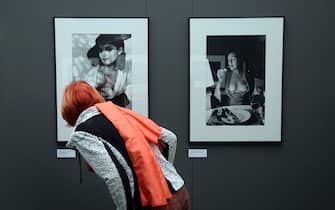 epa04494470 A woman looks at the photographs 'Nastassja Kinski with Marlene Dietrich doll' (L) and 'June, after dinner in our kitchen' by German-Australian photographer Helmut Newton at the German Photography Museum in Markkleeberg, Germany, 18 November 2014. Under the heading 'Masterpieces', the museum is showcasing fifty famous international photographers of the 20th century until 01 March 2015. Iconic photographs as well as lesser-known works will be on display.  EPA/HENDRIK SCHMIDT