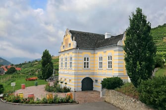 DURNSTEIN, AUSTRIA - JULY 27: DomÃ¤ne Wachau's Baroque-style landmark chateau, which was completed in 1719, is seen nestled between the award-winning winery's vineyards on July 27, 2019 in the Wachau Valley village of DÃ¼rnstein, Austria. DomÃ¤ne Wachau, the biggest winery in the region with a history going back at least 300 years, was recently chosen as #19 on the 2019 list of the Worldâ  s Best Vineyards. (Photo by David Silverman/Getty Images)