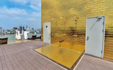 Guests pose for selfies at the infinity pool of the newly-inaugurated Dolce Hanoi Golden Lake hotel, the world's first gold-plated hotel, in Hanoi on July 2, 2020. (Photo by Manan VATSYAYANA / AFP) (Photo by MANAN VATSYAYANA/AFP via Getty Images)