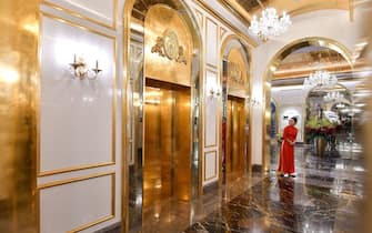 A staff member stands near the lifts in the lobby of the newly-inaugurated Dolce Hanoi Golden Lake hotel, the world's first gold-plated hotel, in Hanoi on July 2, 2020. (Photo by Manan VATSYAYANA / AFP) (Photo by MANAN VATSYAYANA/AFP via Getty Images)