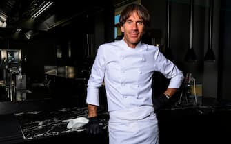 Italian Michelin-starred chef Davide Oldani, wearing protective gloves, poses at his flagship restaurant "D'O" in San Pietro all'Olmo, Cornaredo, west of Milan, on May 21, 2020, as the country eases its lockdown aimed at curbing the spread of the COVID-19 infection, caused by the novel coronavirus. - Renowned chef Davide Oldani considers himself rather privileged with his spacious starred restaurant, the D'O in Cornaredo, which room and tables are large enough to easily comply with the rules of distancing. Still closed, he has taken advantage of the quarantine period to carry out some work. (Photo by MIGUEL MEDINA / AFP)