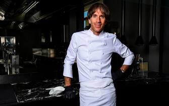 Italian Michelin-starred chef Davide Oldani, wearing protective gloves, poses at his flagship restaurant "D'O" in San Pietro all'Olmo, Cornaredo, west of Milan, on May 21, 2020, as the country eases its lockdown aimed at curbing the spread of the COVID-19 infection, caused by the novel coronavirus. - Renowned chef Davide Oldani considers himself rather privileged with his spacious starred restaurant, the D'O in Cornaredo, which room and tables are large enough to easily comply with the rules of distancing. Still closed, he has taken advantage of the quarantine period to carry out some work. (Photo by MIGUEL MEDINA / AFP)