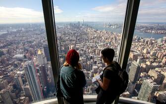 NEW YORK, NY - OCTOBER 10: Visitors look toward Lower Manhattan inside the newly renovated 102nd floor observatory of the Empire State Building on October 10, 2019 in New York City. Opening to the public on October 12, the new 102nd floor observatory is 1250 feet above street level and features 360 degree views of New York City. (Photo by Drew Angerer/Getty Images)