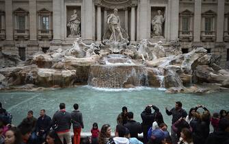 ROME, ITALY - MARCH 25:  Tourists visit the Trevi Fountain on March 25, 2013 in Rome, Italy. Pope Francis yesterday led his first mass of Holy Week as pontiff by celebrating Palm Sunday in front of thousands of faithful and clergy.  (Photo by Jeff J Mitchell/Getty Images)