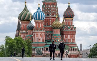 Russian policemen patrol Red Square with Saint Basil Cathedral in the background in central Moscow on May 17, 2020, during a strict lockdown in Russia to stop the spread of the novel coronavirus COVID-19. (Photo by Yuri KADOBNOV / AFP) (Photo by YURI KADOBNOV/AFP via Getty Images)
