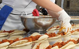 epaselect epa04622174 A Mexican chef prepares a line of 44,000 tacos during gastronomic activities at 'Eating' festival in Guadalajara, Mexico, 15 February 2015. The tacos line measured 2,757 meters and was made with 36,145 kg of tortillas, a ton of meat, and 300 liters of sauce.  EPA/ULISES RUIZ BASURTO