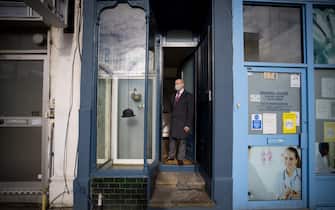 Estate agent David Myers stands in the doorway of what is dubbed 'London's thinnest house' (painted blue) in west London on February 5, 2021. - Wedged neatly between a doctor's surgery and a shuttered hairdressing salon, the five floor house in Shepherds Bush is just 5ft 6ins (1.6 metres) at its narrowest point and is currently on the market for £950,000 ($1,300,000, 1,100,000 euros). The unusual property, originally a Victorian hat shop with storage for merchandise and living quarters on its upper floors, was built sometime in the late 19th or early 20th century. (Photo by Tolga Akmen / AFP) (Photo by TOLGA AKMEN/AFP via Getty Images)