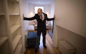 Estate agent David Myers leads a tour of what is dubbed 'London's thinnest house' in west London on February 5, 2021. - Wedged neatly between a doctor's surgery and a shuttered hairdressing salon, the five floor house in Shepherds Bush is just 5ft 6ins (1.6 metres) at its narrowest point and is currently on the market for £950,000 ($1,300,000, 1,100,000 euros). The unusual property, originally a Victorian hat shop with storage for merchandise and living quarters on its upper floors, was built sometime in the late 19th or early 20th century. (Photo by Tolga Akmen / AFP) (Photo by TOLGA AKMEN/AFP via Getty Images)
