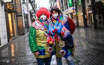 COLOGNE, GERMANY - FEBRUARY 15: A lone pair of carnival enthusiasts walk past shuttered shops in the city center on Rose Monday, the day that is normally the height of Germany's carnival season, during the second wave of the coronavirus pandemic on February 15, 2021 in Cologne, Germany. Carnival celebrations have been cancelled nationwide this year as part of ongoing lockdown measures. (Photo by Lukas Schulze/Getty Images)