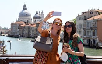 1233247308 Tourists take selfie pictures on the Ponte dell'Accademia bridge over the grand canal in Venice on June 03, 2021. (Photo by ANDREA PATTARO / AFP) (Photo by ANDREA PATTARO/AFP via Getty Images)