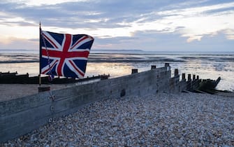 A Union Jack flag flutters in a soft breeze  over a low-tide evening beach sunset, on 27th July 2021, in Whitstable, Kent, England. (Photo by Richard Baker / In Pictures via Getty Images)