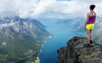 A photographer's girlfriend stands at the top of a mountain. BREATH-TAKING images show a female mountain climber standing perilously above the clouds. The collection of spectacular shots shows one photographer’s girlfriend standing at 5,000-feet up whilst overlooking the beautiful Norwegian fjords. Other images show her perching on a ledge as though she is sitting on top of the world. Norwegian warehouse worker Johan Kistrand (33) walked for up to five hours to each location to capture the beautiful images. Accompanied by his girlfriend who also features in the shots, the locations were situated anywhere between six and eighteen miles apart.