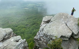 Tourists enjoy the view at the Big Schloss (2,964 feet), the peak of the Ridge and Valley Appalachians, on the border of Virginia and West Virginia on August 8, 2020. (Photo by Daniel SLIM / AFP) (Photo by DANIEL SLIM/AFP via Getty Images)