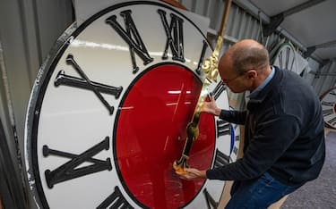 27 October 2021, Bavaria, Regensburg: SÃ¶ren Draack, managing director of the tower clock manufacturer Rauscher holds a hand in front of the dial of a tower clock. On Sunday (31.10.2021) the clock will be set back from three to two o'clock winter time. Photo: Armin Weigel/dpa (Photo by Armin Weigel/picture alliance via Getty Images)