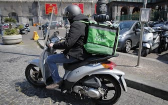 NAPLES, CAMPANIA, ITALY - 2021/03/26: An Uber Eats delivery driver rides his scooter on street during the COVID-19 Coronavirus pandemic in Naples, Campania regione, southern Italy. Delivery services have seen their activities increased due to the mandatory lockdown imposed by the government to help curve down COVID-19 contagion. (Photo by Salvatore Laporta/KONTROLAB/LightRocket via Getty Images)