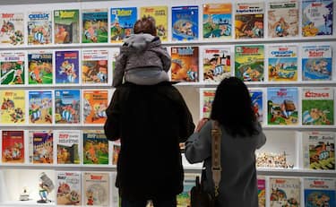 Visitors look at comics displayed during the exhibition 'Uderzo like a magic potion' at the Maillol Museum, in Paris, on May 26, 2021. - The spontaneous line of the workaholic Asterix cartoonist, Albert Uderzo, is on display from May 27, 2021 until September 30 at the Maillol Museum in Paris.
 - RESTRICTED TO EDITORIAL USE - MANDATORY MENTION OF THE ARTIST UPON PUBLICATION - TO ILLUSTRATE THE EVENT AS SPECIFIED IN THE CAPTION (Photo by BERTRAND GUAY / AFP) / RESTRICTED TO EDITORIAL USE - MANDATORY MENTION OF THE ARTIST UPON PUBLICATION - TO ILLUSTRATE THE EVENT AS SPECIFIED IN THE CAPTION / RESTRICTED TO EDITORIAL USE - MANDATORY MENTION OF THE ARTIST UPON PUBLICATION - TO ILLUSTRATE THE EVENT AS SPECIFIED IN THE CAPTION (Photo by BERTRAND GUAY/AFP via Getty Images)
