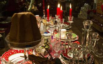 TREVISO, ITALY - DECEMBER 06:  A Pandoro and candles are seen on a Christmas decorated table on December 6, 2011 in Treviso, Italy. Christmas Markets are popular in Northern Italian cities, selling festive items including lights, nativity scenes, decorations and local festive handicrafts. In most cities they will run from the end of November to January 6th.  (Photo by Marco Secchi/Getty Images)