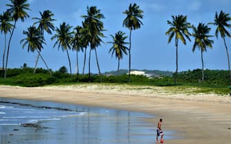 A man plays football on the beach in Natal, on June 12, 2014 a few hours before the opening game of the 2014 Fifa World Cup in Brazil. AFP PHOTO / GABRIEL BOUYS        (Photo credit should read CHRISTOPHE SIMON/AFP via Getty Images)