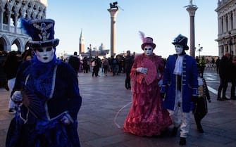 Masked revellers wearing a traditional carnival costume pose in St Mark Square during Venice's Carnival on February 12, 2022. (Photo by Tiziana FABI / AFP) (Photo by TIZIANA FABI/AFP via Getty Images)