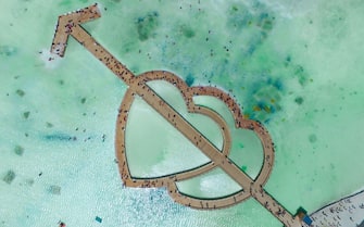 HAIXI, CHINA - AUGUST 08: Aerial view of people visiting a hearts-shaped bridge at Chaka Salt Lake on August 8, 2019 in Haixi Mongol and Tibetan Autonomous Prefecture, Qinghai Province of China. (Photo by Zhu Haihua/Visual China Group via Getty Images)
