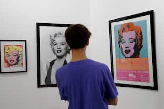 A man looks at art creations by US artist Andy Warhol displaying US actress Marilyn Monroe, during the exhibition "Divine Marylin", on July 12, 2019 at the Joseph galery in Paris. (Photo by FRANCOIS GUILLOT / AFP) / RESTRICTED TO EDITORIAL USE - MANDATORY MENTION OF THE ARTIST UPON PUBLICATION - TO ILLUSTRATE THE EVENT AS SPECIFIED IN THE CAPTION        (Photo credit should read FRANCOIS GUILLOT/AFP via Getty Images)
