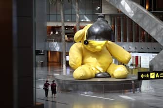 This picture taken on March 31, 2020 shows a view of a giant 23-foot-long canary-yellow sculpture of a teddy bear sitting inside a lamp, at Hamad International Airport in the Qatari capital Doha, almost empty due to the COVID-19 coronavirus pandemic. (Photo by KARIM JAAFAR / AFP) (Photo by KARIM JAAFAR/AFP via Getty Images)