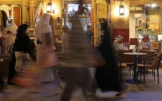 Qataris drink coffee as others walk at Qatar's touristic Souq Waqif bazar in the capital Doha on November 28, 2021. (Photo by Karim SAHIB / AFP) (Photo by KARIM SAHIB/AFP via Getty Images)