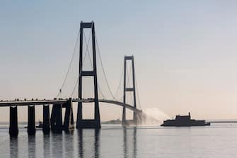 KORSOER, DENMARK - MAY 04: The worlds only floating atomic power station, Akademic Lomonosov, passes under the Great Belt Bridge on its way to Murmansk in Russia on May 4, 2018 in Korsoer, Denmark. Akademic Lomonosov was towed out of St. Petersburg harbour on Saturday, is built on a barge and has a length of 144 metres and a width of 30 metres. It is the first of its kind globally and is said to be capable of producing power for a town of up to 100,000 people. The Swedish and Norwegian governments have raised concerns about the risk of an accident at sea and Greenpeace has branded Akademic Lomonosov a 'floating Chernobyl' and a 'nuclear Titanic'. The towed barge is being followed by Danish Navy vessels and a Greenpeace ship on its way through Danish waters, which it is expected to leave late Sunday. (Photo by Ole Jensen - Corbis/Getty Images)