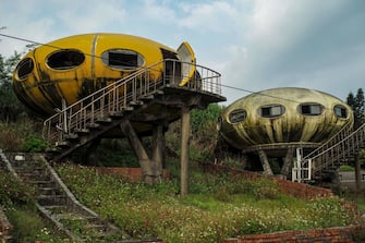 This picture taken on October 4, 2022 shows abandoned unidentified flying object (UFO) shaped houses at the Feitsui beach, also as know as Emerald Bay or Green Bay, in Wanli District, New Taipei City. - The abandoned UFO houses were reformed from Finnish architect Matti Suuronen design 'Futuro House' by Taiwanese businessman Su Ming in 1980. (Photo by Sam Yeh / AFP) (Photo by SAM YEH/AFP via Getty Images)