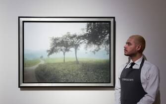 LONDON, UNITED KINGDOM - OCTOBER 14: An art handler looks at a painting titled 'Apfelbaume' by Gerhard Richter (estimate: $5,000,000-7,000,000) during a photo call to present the highlights from the estate of the philanthropist and co-founder of Microsoft, Paul G. Allen in London, United Kingdom on October 14, 2022. The collection of over 150 masterpieces, valued in excess of $1 Billion, will be offered at an auction on 9 and 10 November at Rockefeller Center in New York, with all proceeds dedicated to philanthropic causes. (Photo by Wiktor Szymanowicz/Anadolu Agency via Getty Images)