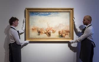 LONDON, UNITED KINGDOM - OCTOBER 14: Art handlers hold a painting titled 'Depositing of John Bellini's Three Pictures in La Chiesa Redentore, Venice' by Joseph Mallord William Turner (estimate on request: in excess of $30,000,000) during a photo call to present the highlights from the estate of the philanthropist and co-founder of Microsoft, Paul G. Allen in London, United Kingdom on October 14, 2022. The collection of over 150 masterpieces, valued in excess of $1 Billion, will be offered at an auction on 9 and 10 November at Rockefeller Center in New York, with all proceeds dedicated to philanthropic causes. (Photo by Wiktor Szymanowicz/Anadolu Agency via Getty Images)