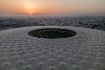DOHA, QATAR - JUNE 22: (EDITORS NOTE: This photograph was taken using a drone) An aerial view of Al Thumama stadium at sunset on June 22, 2022 in Doha, Qatar. Designed by the architect Ibrahim M. Jaidah, the stadiumâ  s bold, circular form reflects the gahfiya â   a traditional woven cap adorned by men and boys all across the Middle East for centuries. Al Thumama stadium is a host venue of the FIFA World Cup Qatar 2022 starting in November. (Photo by David Ramos/Getty Images)